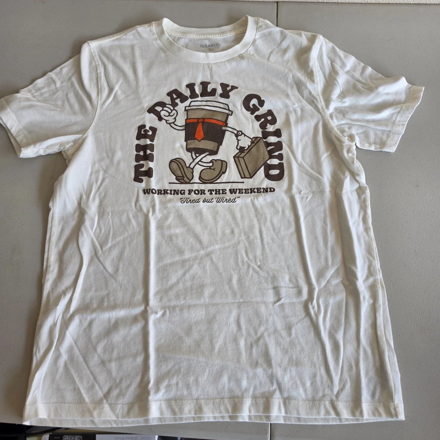 The Daily Grind Shirt by Old Navy Coffee Cup Graphic Cream Color Adult Size M Unisex T-shirt, Sweatshirt, Hoodie, Long Sleeve Tee - T-Shirt, Sweatshirt, Hoodie